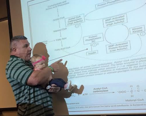 Baylor University Professor Darryn Willoughby lectures while holding 4-month-old Millie, whose babysitter was a no show March 2. Willoughby said he held the girl for nearly an hour as he taught so that her mother, Katy Humphrey, could focus on class. (Photo courtesy of Darryn Willoughby)
