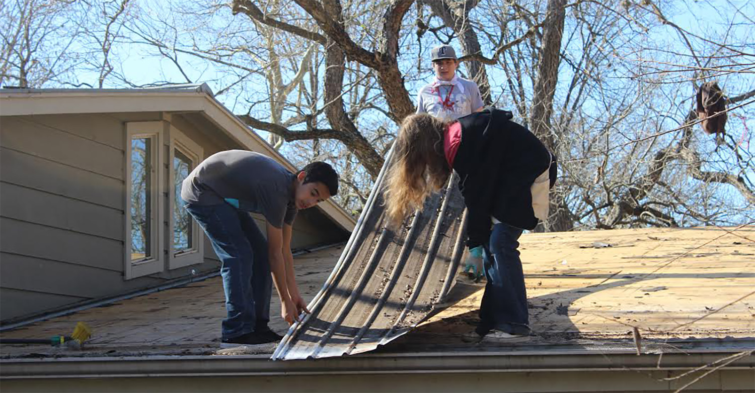 Youth work on a damaged roof in Wimberley, Texas. (Photo/Ty McAllister)