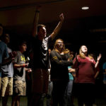 Geyna Moore, 19, raises up her hands amongst other students during a worship service at the Baptist Campus Ministry at Western Kentucky University in Bowling Green