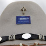 Kraig Moss poses for a photo with a cross and button on his hat before U.S. Republican presidential candidate Donald Trump speaks at a campaign event in an airplane hangar in Rome, New York