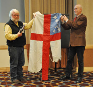 John Floberg (left) recently presented the Episcopal Church flag which has flown over the camp of water protectors at Standing Rock to the church's archivist, Mark Duffy. It was the only Christian church flag flying at the camp. (Mary Frances Schjonberg/Episcopal News Service)